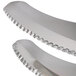 A close-up of a silver serrated blade with fine teeth.