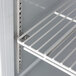 A close-up of a shelf with a metal rack inside a Beverage-Air worktop freezer.