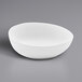 A white GET Enterprises Riverstone melamine bowl on a gray surface.
