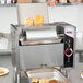 An APW Wyott vertical conveyor bun grill toaster with bread inside.