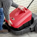 A person using a Viper manual push sweeper to clean a floor.