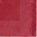 A burgundy cloth napkin with a square edge.