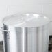 A Vollrath stainless steel lid on a large silver pot.