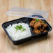 A black Pactiv plastic VERSAtainer with rice and meat in it and a lid.