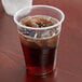 A Lavex translucent plastic cup filled with a brown drink on a table.