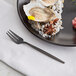 An Acopa Odin stainless steel fork next to a plate of oysters.