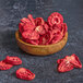 Freeze-dried strawberry slices in a wooden bowl.