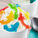 A cup of ice cream with Vidal assorted color gummy sharks in it.