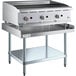 A large stainless steel Cooking Performance Group lava briquette charbroiler on a stainless steel Regency Equipment Stand with knobs.