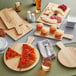 An Acopa faux wood melamine serving board with pizza, bread, and cheese on it.