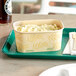 A World Centric rectangular compostable container filled with mashed potatoes on a tray.