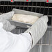 A person wearing white gloves using a Chicago Metallic bread loaf pan to bake white dough.