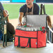 A man opening a red Choice insulated cooler bag filled with cans of beer.