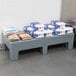 A Winholt dunnage rack with bags of food on a table.