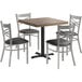 A Lancaster Table & Seating butcher block table with a metal base and four black chairs with black cushions around it.