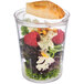 An APS Super Cup reusable plastic container with a salad and bread inside.