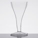 A clear Fineline Tiny Temptations square wine glass with a cone-shaped base on a table.