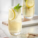 A glass of Davidson's Organic Lemon Spearmint Herbal Iced Tea with lemon slices and mint leaves.