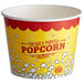A yellow and red Carnival King popcorn bucket with white and red text full of popcorn.