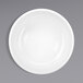 A bright white porcelain bowl with a circular pattern on a gray surface.
