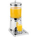 A stainless steel beverage dispenser on a metal stand with a glass of orange juice on it.