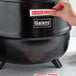 A hand putting a sticker on a black Galaxy Soup Kettle.