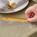 A hand holding a gold Choice pocket crumber over a table