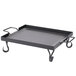 A black rectangular metal tray with handles on a metal stand.