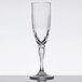 A clear GET SAN plastic champagne flute with a fluted design and a stem on a table.