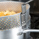 A Vollrath 12 Qt. fryer pot replacement basket with food inside.