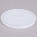 A white plastic lid with a straw slot and a cross.