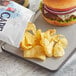 A plate with a burger and a bag of Cape Cod Original Sea Salt Kettle Cooked Potato Chips.
