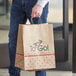 A man holding a Bagcraft natural Kraft paper shopping bag with "Meals to Go" logo.