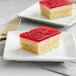 Two squares of Eli's Lemon Raspberry Vegan Cheesecake with a white background.