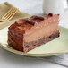 A slice of Eli's Cheesecake with Ghirardelli chocolate fudge on a plate.