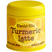 A yellow container of David Rio Turmeric Latte mix with a yellow lid on a counter.