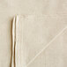 A folded beige canvas drop cloth with white background.