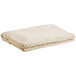 A folded beige canvas drop cloth on a white background.