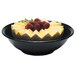 A black Cambro salad bowl with fruit including raspberries and melon.