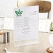 A Choice acrylic tabletop displayette holding a menu on a restaurant table.