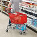 A man shopping at a grocery store, pushing a Regency red plastic grocery cart.