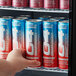 A hand holding a red C4 SMART Energy Cherry Berry Lime energy drink can taken out of a refrigerator.