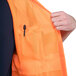 A person wearing a Cordova orange high visibility safety vest.