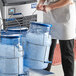 A woman in an apron using the Vigor ice tote to carry ice.