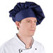 A man wearing a navy blue Intedge chef hat.