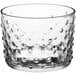A clear glass cylindrical votive candle holder with a small textured pattern.