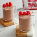 A glass mug of Land O Lakes Raspberry and Chocolate hot cocoa with raspberries on top.
