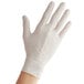 A person's hand wearing a small white powdered latex glove.