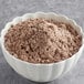 A bowl of brown Pillsbury Bakers' Plus Devil's Food Cake mix powder.