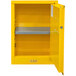 A yellow Durham Mfg steel safety cabinet with a shelf and a manual door.